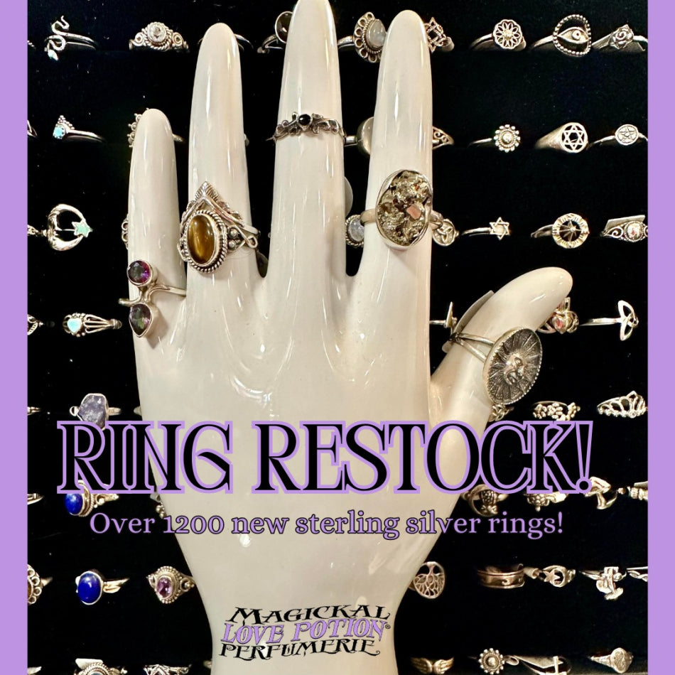 A palm reading hand wearing our rings with a drawer of more rings in the background.