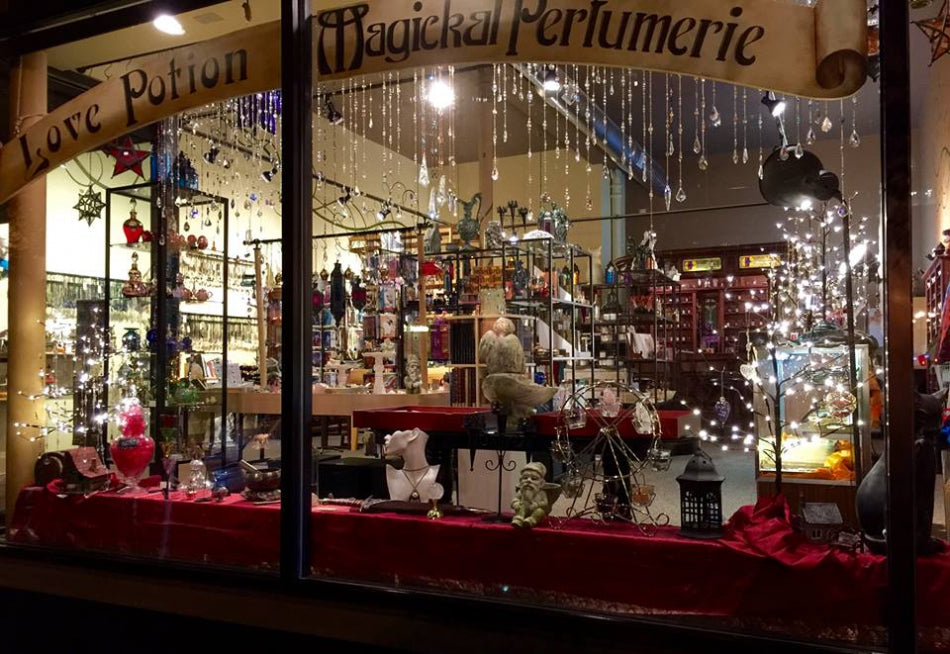 Love Potion Magical Perfumerie store front with various products and decorations, including crystal sun catchers.
