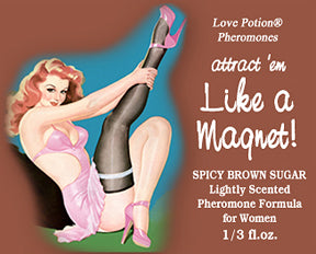 Like a Magnet pheromone oil with spicy brown sugar fragrance label shows a pinup girl in pink and black